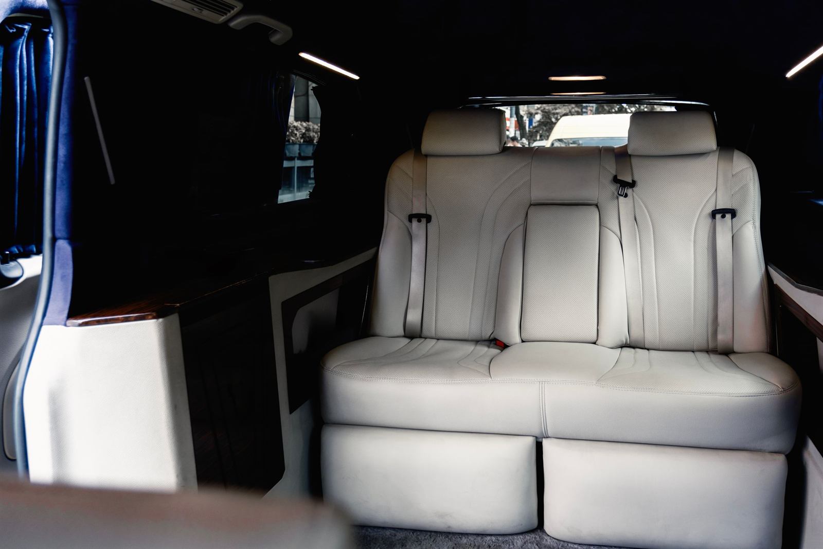 The inside of a van fitted as a lounge, two light leather armchairs